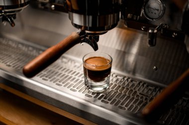 Profesyonel kahve makinesinin çelik yüzeyinde kahve bardağı manzarası