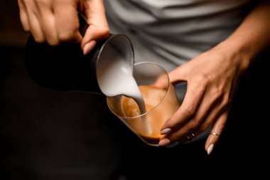 Kadınlara yakın çekim. Sürahiden bardağa krema döküyorlar. Kahve içiyorlar.