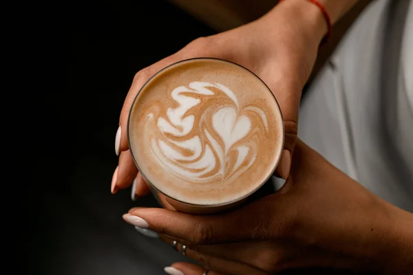 Kadının elinde kahve içeceği olan harika bir cam manzarası. Köpük üzerindeki güzel desen — Stok fotoğraf