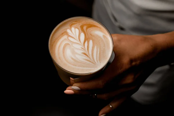 Vista superior de la bebida de café con patrón de figura en espuma en vidrio en la mano de las mujeres —  Fotos de Stock