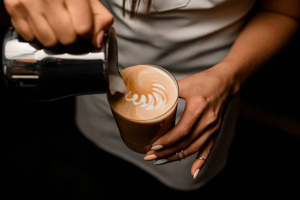 Kahveci kadının sütünü latteyle bardağa dökerken yakın plan fotoğrafı. — Stok fotoğraf