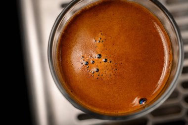 Kahverengi köpüğe yakın çekim, yuvarlak bardakta kahve köpüğü.