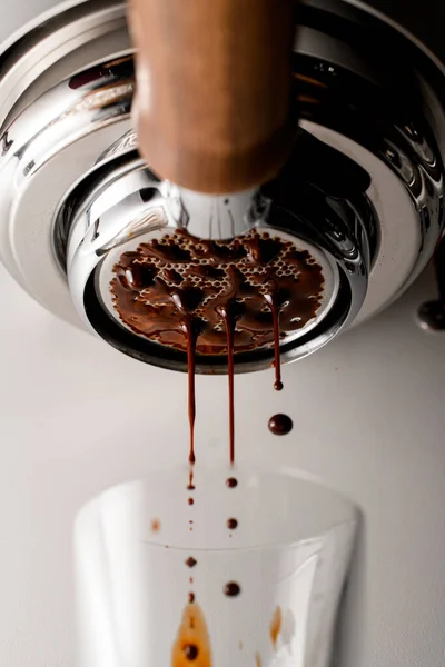 Tropfen frischen heißen Espresso-Kaffees, die durch Portafilter in klares Glas gegossen werden — Stockfoto