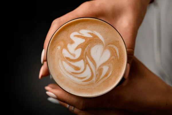 Kadının elinde kahve içeceği olan cam manzaralı bir yer. Köpük üzerindeki güzel desen — Stok fotoğraf