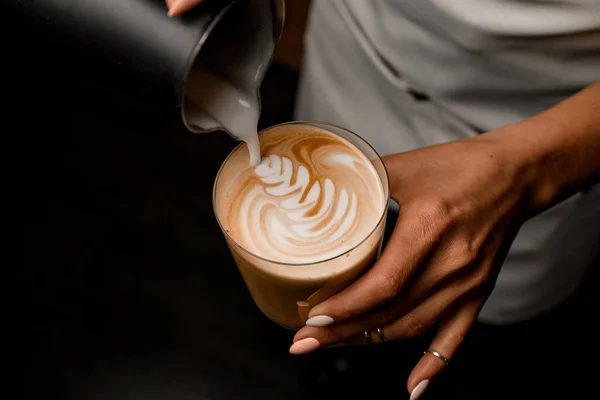 Kahvecinin yakın plan resmi. Sütü latteyle bardağa döküyor. — Stok fotoğraf
