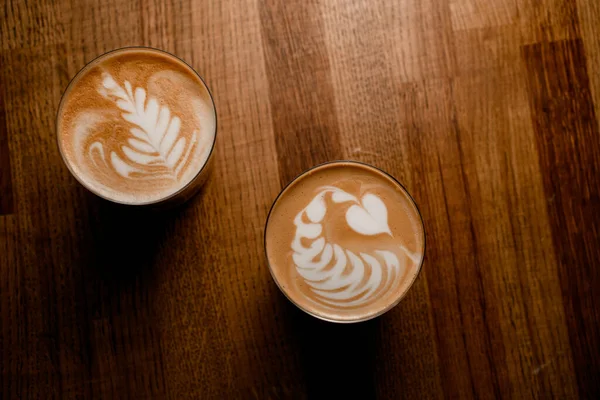 Vue de dessus des verres de café avec latte art avec belle mousse de lait de café — Photo