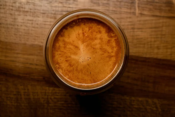 Ovanifrån av runt glas med skummande kaffedrycker på träbord — Stockfoto