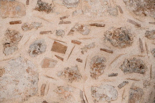Textura close-up de parede feita de pedras e conchas de diferentes formas e tamanhos — Fotografia de Stock
