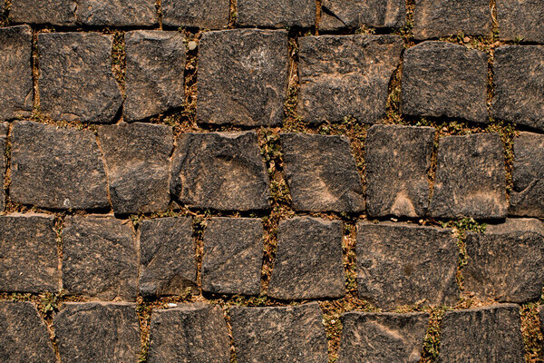 dark granite cobblestone pavement background. Natural stone textured background. Paving texture