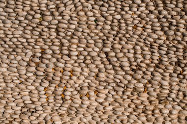 Beyaz, küçük çakıl taşları üzerindeki üst manzara yolda bir sırada asfaltlandı. Mozaik çakıllar.