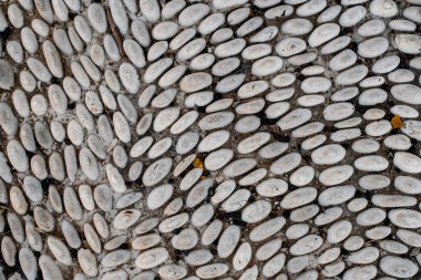 Yoldaki bir sıranın üzerine döşenmiş küçük çakıl taşları üzerinde güzel bir manzara. Mozaik çakıllar.