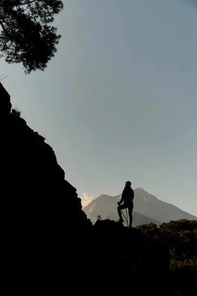 Чудовий вид силуету жінки з пішохідними полюсами на тлі неба і гір — стокове фото