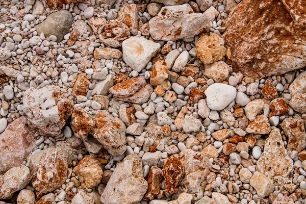 Muchas piedras coloridas naturales de diferentes formas y tamaños. Textura de roca. — Foto de Stock