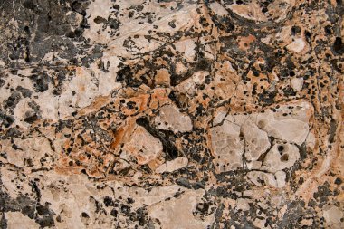 Üzerinde güzel erozyon dokusu ve desenleri olan eski taş yüzeyin yakın görüntüsü.