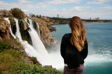 Türkiye 'nin Antalya kentindeki Duden şelalesinin arka planında güzel bir kadının dikiz görüntüsü.