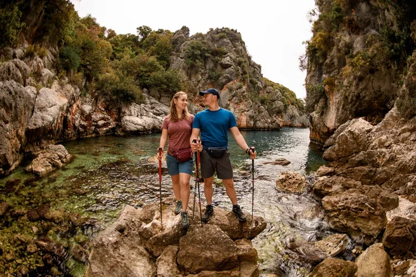 Uitzicht op man en vrouw die op steen staan tegen de achtergrond van het natuurlandschap — Stockfoto