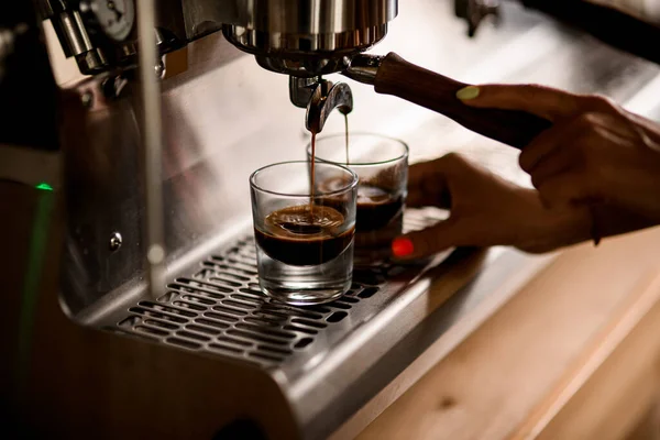 Recién hecho café espresso caliente se vierte de la máquina de café en tazas de vidrio —  Fotos de Stock