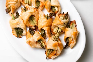 Beyaz tabakta Fransız pastasına sarılmış lezzetli kuşkonmaz manzarası..