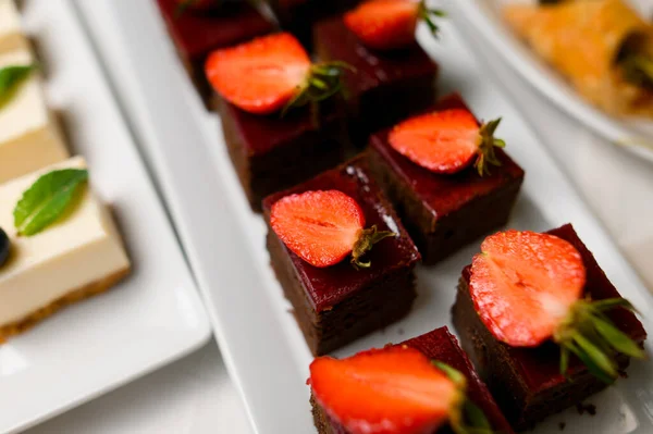 ホワイトプレートにイチゴとチョコレートブラウニーのクローズアップビュー部分. — ストック写真