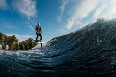 Aktif bir adam hidrofolyo folyoyla dalgalarda yüzüyor.