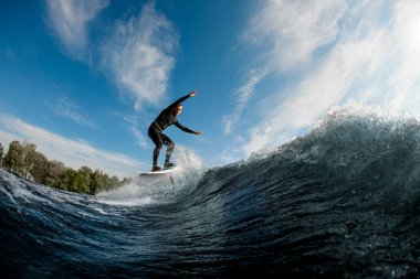 Aktif adam hidrofolyo levhasıyla dalgada koşuyor.