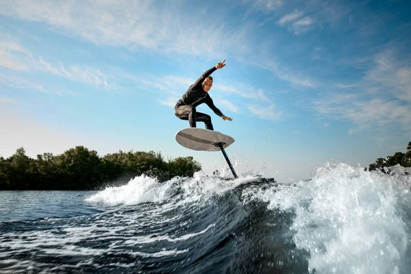 Atlético hombre equilibrio en foilboard en ola en día soleado — Foto de Stock