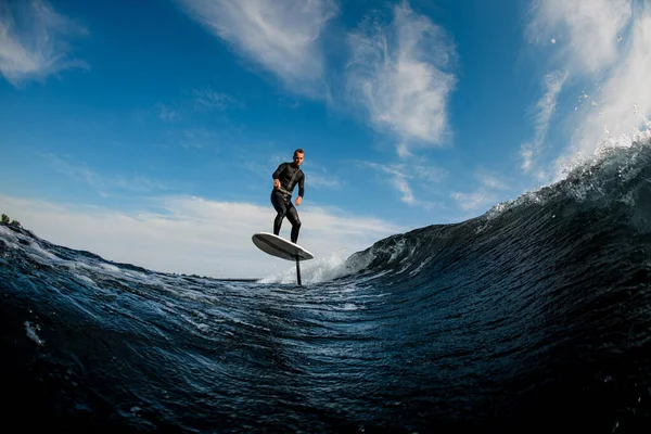 Bela vista do homem montando na onda com placa de folha de hidrofolha — Fotografia de Stock