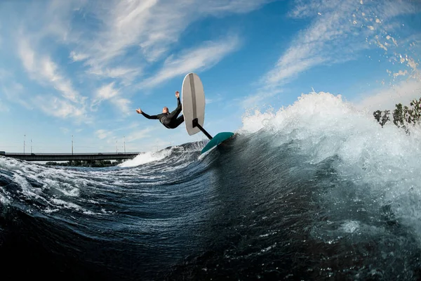 Красивий вид людини високо стрибає на хвилі з дошкою для фольги — стокове фото