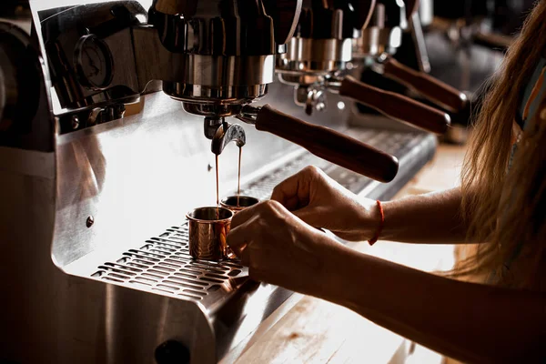 view on professional espresso machine pouring hot coffee into small steel cups