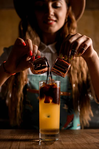 Garçom feminino segura copos com café e derrama-lo em vidro com suco de laranja — Fotografia de Stock
