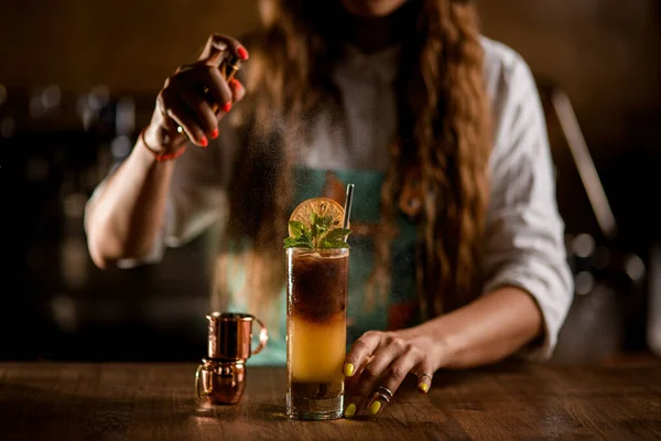 Glass with coffee cocktail stands on the table and female bartender sprinkles on it — Stock Photo, Image