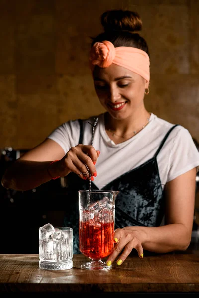 Barista femminile tiene cucchiaio bar in mano e mescola cocktail freddo in tazza di miscelazione — Foto Stock