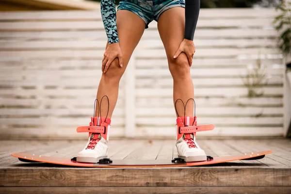 Frontansicht auf Frauenbeine, die in Stiefeln von Wakeboarderbrettern befestigt sind — Stockfoto