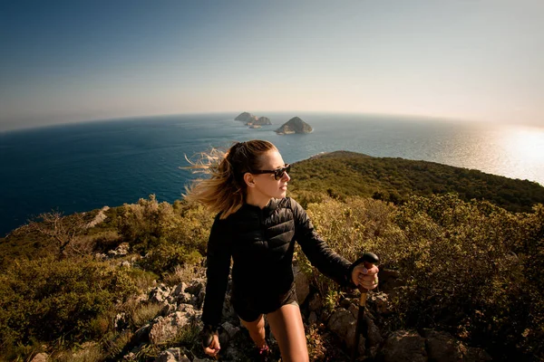 Close-up panoramisch uitzicht op mooie vrouw met wandelpalen op zeegezicht achtergrond — Stockfoto