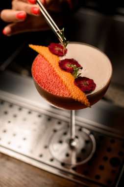 Köpüklü bardak barmen yeşil dallarla süslüyor.