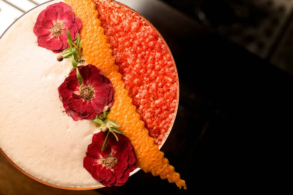 Vue de dessus de belles fleurs séchées et écorce d'orange décoration verre de cocktail mousseux — Photo