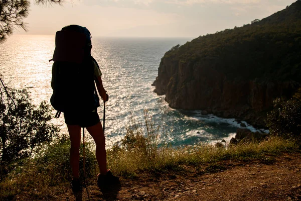 Touriste avec sac à dos et bâtons de randonnée debout sur fond de beau paysage marin — Photo