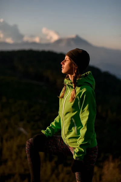 Zijaanzicht van vrouw met gesloten ogen tegen achtergrond van hemel en bergen — Stockfoto