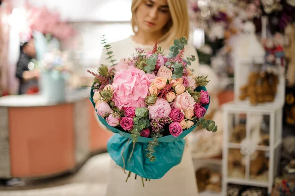 Great flower bouquet wrapped in turquoise wrapping paper in woman hands — Stock Photo, Image
