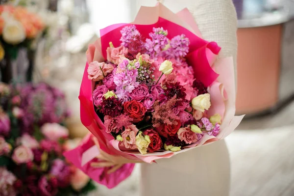 Primer plano de hermoso ramo de varias flores frescas envueltas en papel rosa brillante —  Fotos de Stock