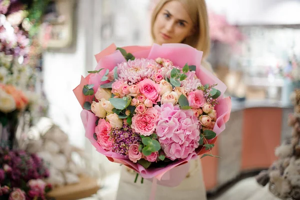 Maravilloso ramo de hortensias de crisantemo rosa y rosas envueltas en papel en manos de mujer. —  Fotos de Stock