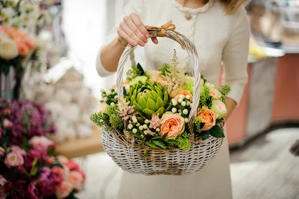 Belle composition de différentes fleurs fraîches en panier en osier blanc dans les mains féminines — Photo