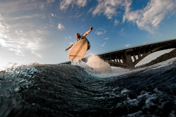 Nagyszerű kilátás a férfi wakeboarder, miközben ugrott át fröccsenő hullám — Stock Fotó