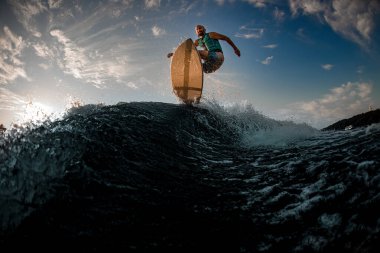 Su sıçratan dalgaların üzerinden atlarken erkek wakeboardcunun muhteşem alt görüntüsü