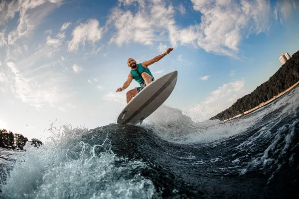 Esportista efetivamente pulando sobre a onda no wakeboarding board — Fotografia de Stock