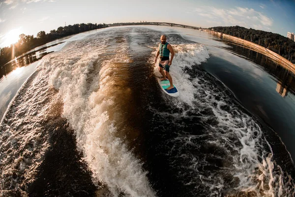 Vista panorámica de alto ángulo del hombre en turquesa chaleco salvavidas olas en wakeboard —  Fotos de Stock