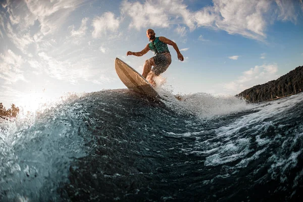 Homem de jaqueta de vida turquesa habilmente desce a onda em um wakesurf — Fotografia de Stock
