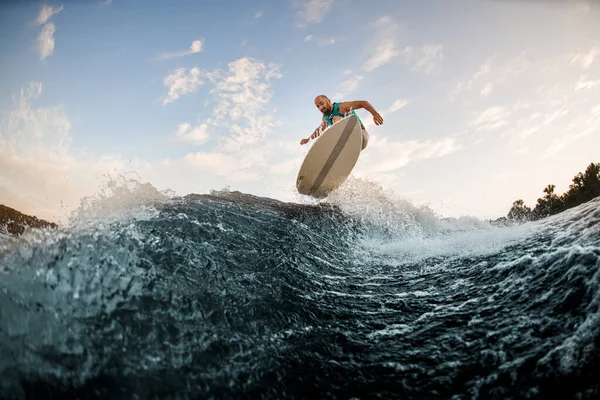 Energia ember hatékonyan ugrik a wakeboard felett fröccsenő hullám. Ébredés a folyón. — Stock Fotó