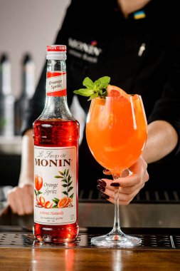 UKRAINE, KYIV - 11 Mart 2021: Bir şişe Portakal Spritz şurubu ve barın üzerinde kokteyl ile cam