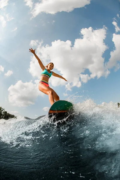 Mujer wakesurfer hábilmente montar la ola salpicadura del río. Deportes acuáticos de verano —  Fotos de Stock